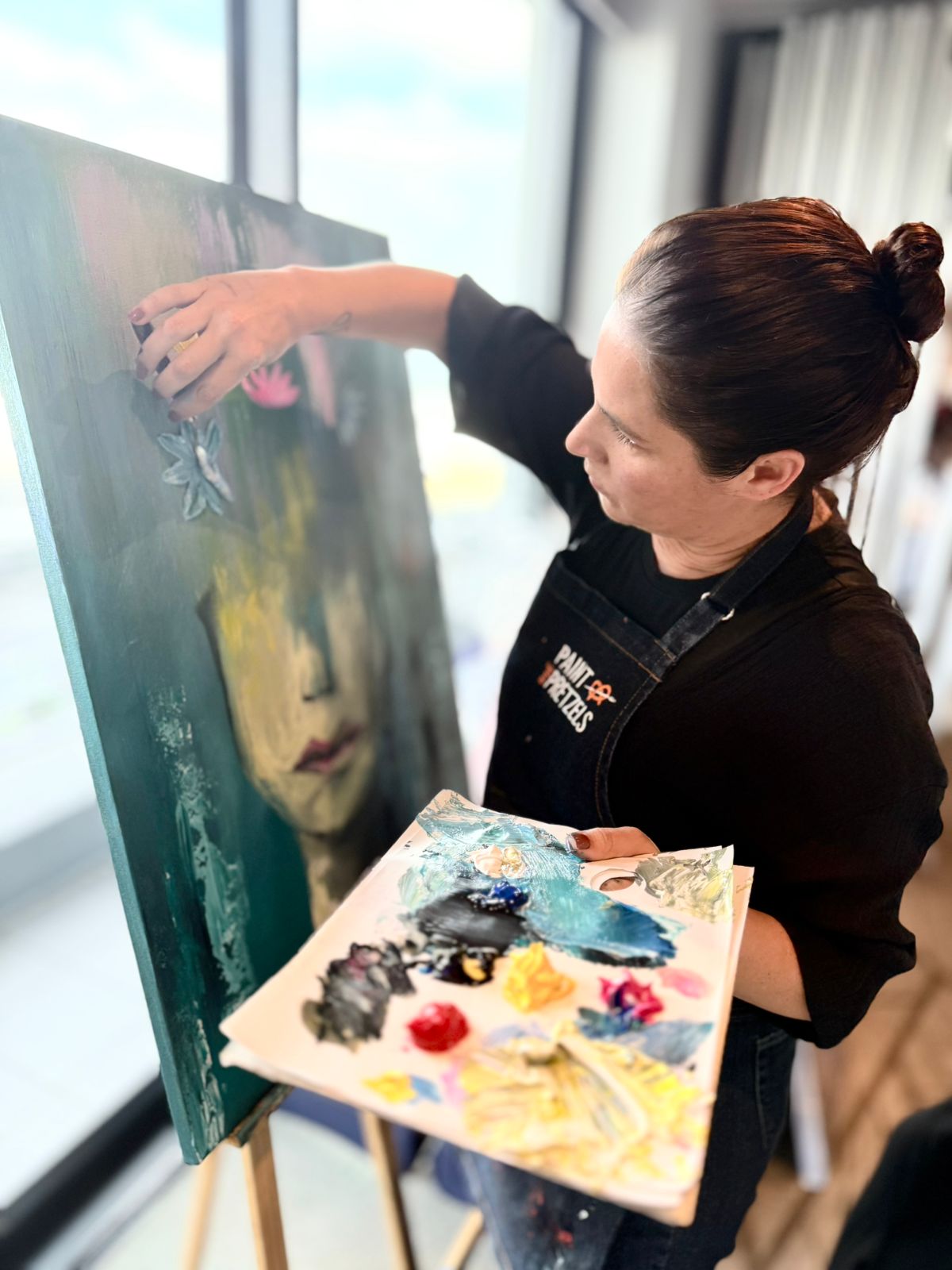 Woman painting at an easel during an event