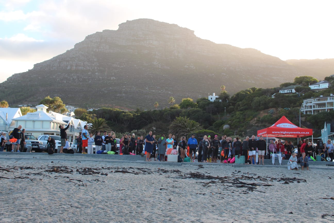 Crowd of swimmers on the beach in late light