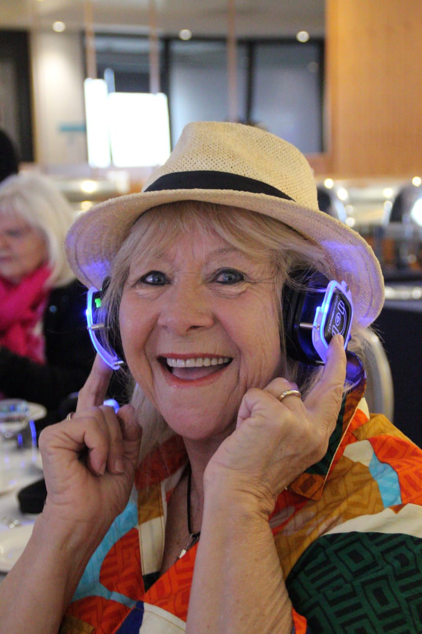 Smiling guest in a hat wearing headphones