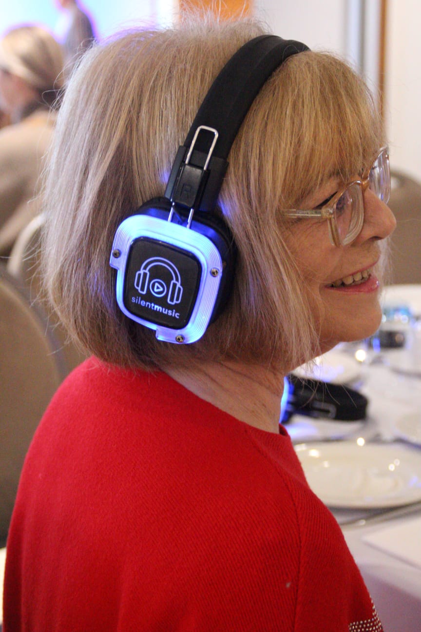 Guest in profile wearing glowing headphones