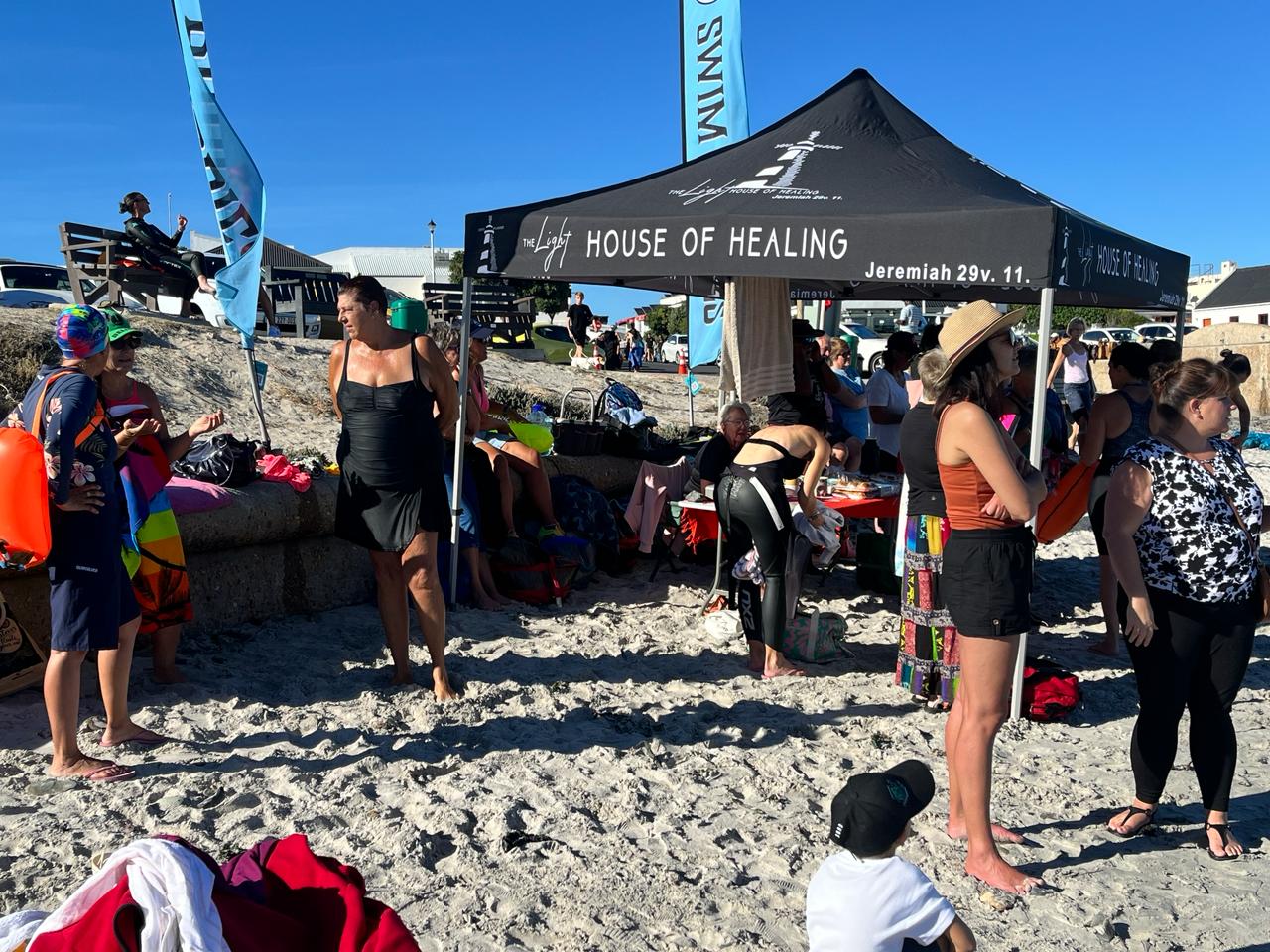Swimmers gathered beside a beach tent