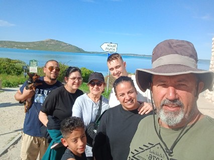 Family selfie outdoors beside the water