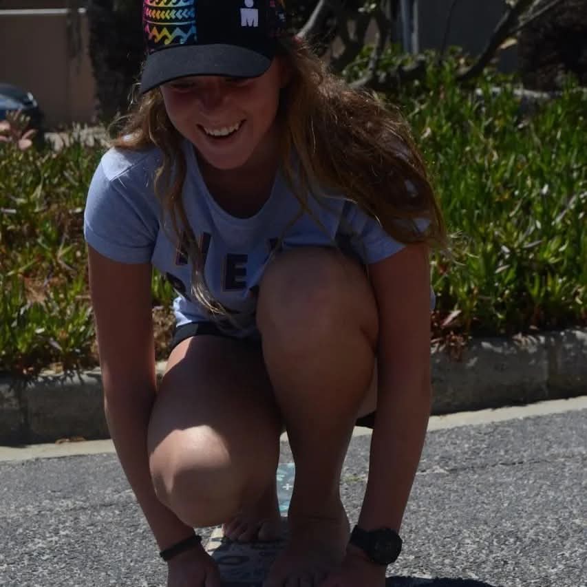 Young woman crouching with a skateboard