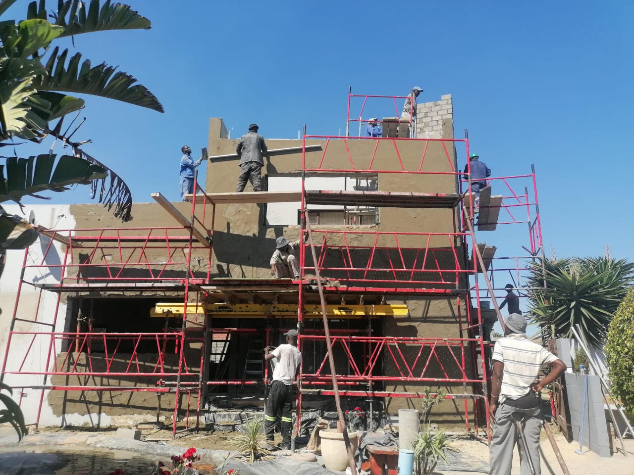 Plasterers working on scaffolding at a house under construction